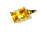 a close up of a yellow stone pendant on a white surface