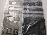 quatre sacs de vêtements posés sur une table blanche