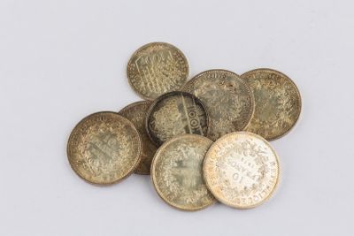 some old coins sitting on top of each other on a white surface