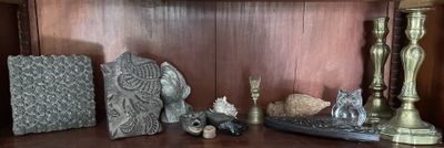 une étagère sur laquelle se trouvent une horloge, des bougies et des figurines