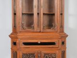 un vieux vaisselier en bois surmonté de portes vitrées