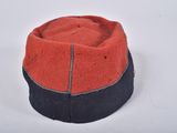a red and black hat sitting on top of a white table