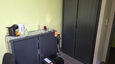 une armoire noire et une chaise noire dans un coin de la pièce