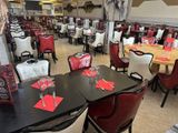 many tables and chairs in this restaurant with red napkins