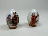 paire d'œufs en porcelaine ornés de motifs peints sur fond blanc