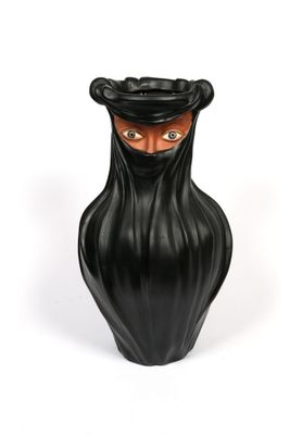 a black vase with a black face and a black hat on it