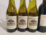 four bottles of wine are lined up on a white surface