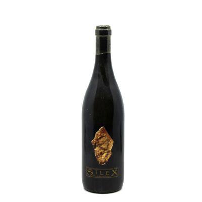 a bottle of wine sitting on top of a white surface