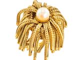gros plan d'une bague en or contenant une perle