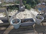 two planters that are sitting on a wooden deck