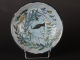 a blue plate with a bird on it on a stand