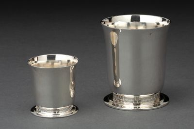 deux tasses en argent posées l'une à côté de l'autre sur une table