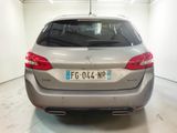 the rear end of a silver car in a white room