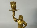 a gold statue of a woman holding a cup on a tray