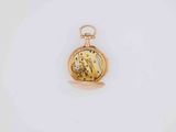 a close up of a gold pocket watch on a white surface