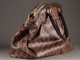 an image of a brown and black handbag on a gray surface