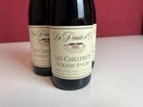 two bottles of wine sitting on a table next to each other