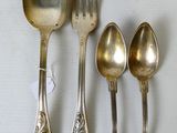 cinq cuillères en argent et deux cuillères en argent sur une table