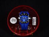 une montre bleue dans un écrin rouge posé sur une surface noire