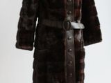 un manteau de fourrure marron posé sur un mannequin, sur fond blanc