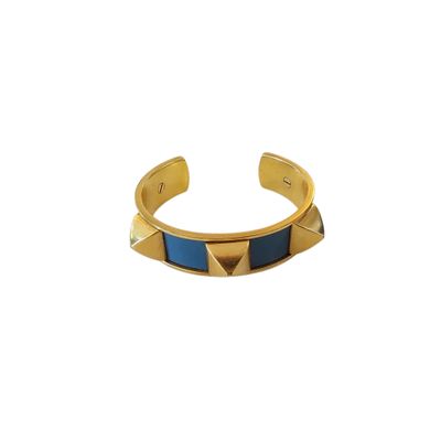 a gold and blue cuff bracelet with pyramids