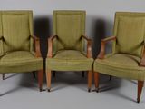 three green upholstered chairs with wooden arms and legs