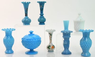 de nombreux vases en verre bleu posés sur une table