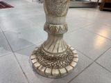 un vase posé sur un socle au milieu d'une pièce