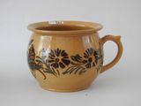 a brown cup with a floral design on it