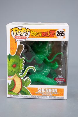 une figurine de dragon vert dans une boîte posée sur une table