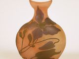un petit vase orné d'une fleur, posé sur une surface blanche