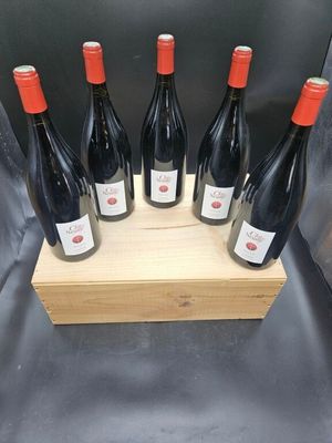 six bouteilles de vin rouge dans un coffret en bois sur fond gris