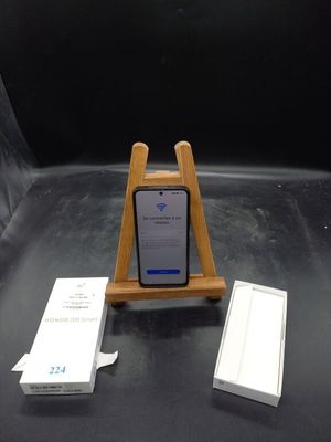 un téléphone portable posé sur un support en bois à côté d'une boîte de mouchoirs