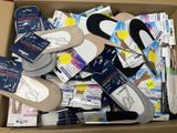 many pairs of shoes in a cardboard box on the floor