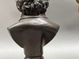 two bronze busts of a man and a woman on pedestals