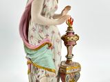 an image of a figurine of a woman standing next to a vase
