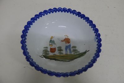 a blue and white bowl with a picture of a man and a woman in a boat