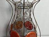 an image of a metal vase with red stones in it