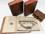 three old books are sitting next to each other on a table