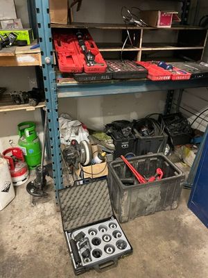 de nombreux outils posés sur une étagère dans un garage