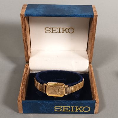 a gold watch in a blue box with a gold band