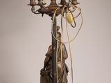 a statue of a man holding a candelab with five candles on it