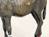a statue of a horse with a shoe on it ' s foot