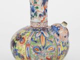un vase coloré orné d'un oiseau, posé sur un fond blanc