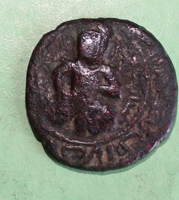 an old coin with a man on it on a green surface