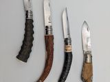 four different types of knives are lined up on a white surface