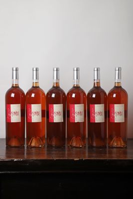 six bouteilles de vin sont alignées sur une table en bois