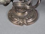 a silver candle holder with a bird on top of it