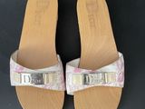 a pair of pink and white sandals with silver buckles