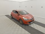 La voiture orange est garée dans le garage, sur le sol à damier.
